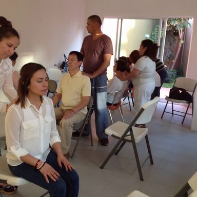 Alumnos practicando la sanación energética con otros alumnos durante un curso presencial de autosanación