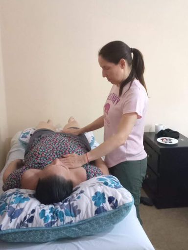 Mujer practicando la imposición de manos en un curso de sanación energética en Cancún
