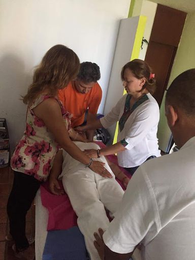 Grupo de personas practicando la imposición de manos en un curso de sanación energética en Cancún
