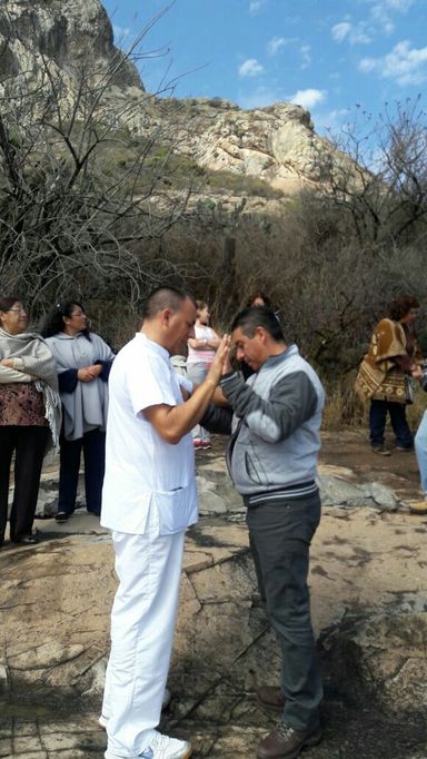 Sesión de sanación energética en la naturaleza. Sanador enseñando y un círculo de alumnos alrededor